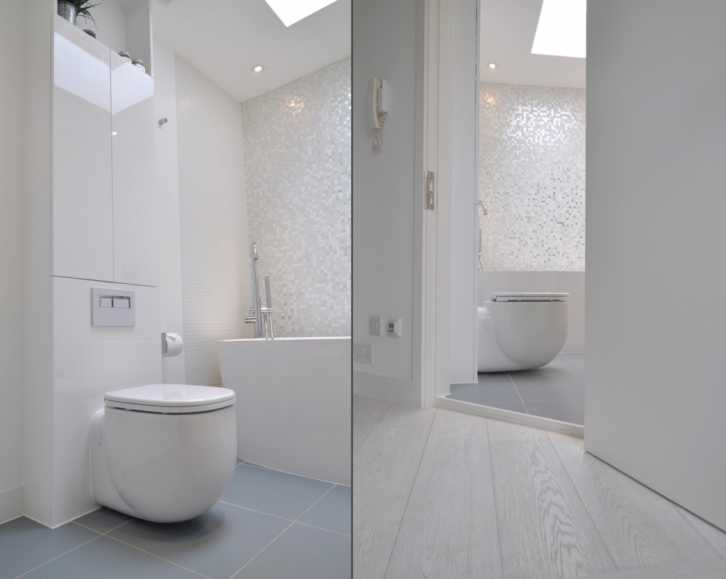 This stunning white-on-white bathroom design contains two different colours of wall tiles, with the splash-back inlaid with white gold.