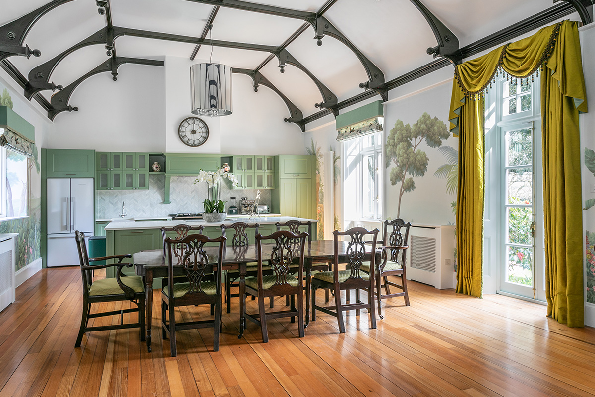 Kitchen and dining room under original timber roof trusses in a Grade II listed manor house in Cornwall