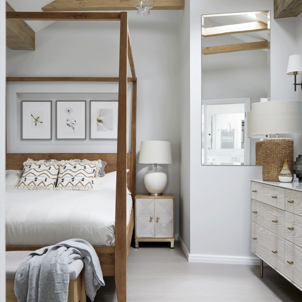 Vaulted bedroom in a Hampstead cottage with exposed beams and the owners' four-poster bed