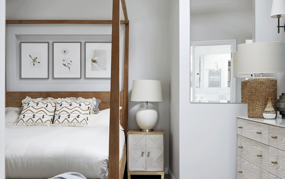 Vaulted bedroom in a Hampstead cottage with exposed beams and the owners' four-poster bed