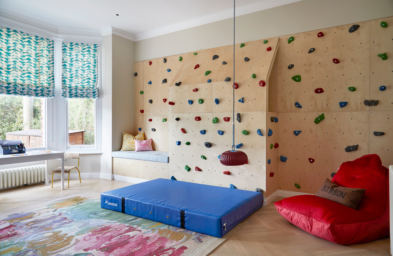 Playroom, featuring climbing walls and vibrant hues to foster creativity and exploration. Designed with ingenious elements and flexible layouts, each space evolves with the family's needs, ensuring longevity and adaptability. Built-in climbing walls offer endless adventures, with heavy-duty PVC and premium foam mattresses from Bee Mat UK. For aspiring climbers in small spaces, explore Climb A Wall's 6 Indoor Panel Climbing Wall Kit. At the heart of the room, find the Monkey Tree Swing from Brave Toys, amidst the excitement.